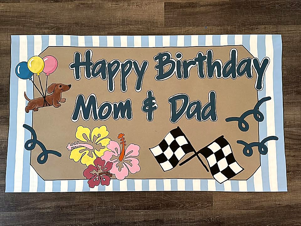 Hand-painted birthday banner for Mom and Dad with balloons, flowers and racing flags